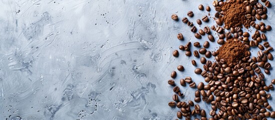 Wall Mural - Roasted and ground coffee beans on a gray surface with space for text. View from above.