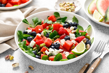 Wall Mural - Watermelon and feta cheese salad with blueberry, raspberry, pistachios and fresh greens