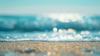 Wall Mural - Close-up shot capturing the pristine beach with sparkling sand and shimmering waves under bright sunlight and crystal-clear skies.