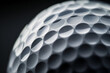 © Jennifer Clason - A close-up view of the surface of a golf ball, focusing on its dimples with a dark, blurred background