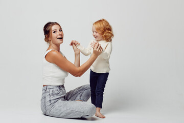 playful mother and daughter bonding time sitting on floor interacting, happy family, love, enjoyment