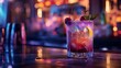 © marco - close up glass with pretty colored drink served with ice on a blurred bar background