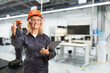 © Ljupco Smokovski - Female worker in a uniform and helmet posing in a factory