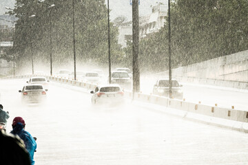 A rainy day with cars driving down a wet road