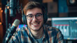 © Napava - Man with headphones smiling while sitting at a table and talking into a microphone for a podcast or radio show