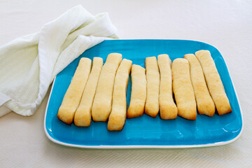 Freshly baked bread sticks; row of bread sticks presented on a plate