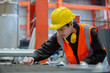 © eakgrungenerd - Male workers wear red helmet working check up iron product in factory. Heavy Industrial manufacturing workplace.