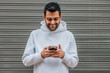 © carballo - young man with mobile phone on the street with blinds in the background