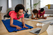 © NDABCREATIVITY - Happy african american fit woman working out with online traning at home. Sport technology concept
