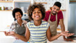 © NDABCREATIVITY - Happy black family in the kitchen having fun and cooking together. Healthy food at home.