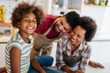 © NDABCREATIVITY - Happy african american family preparing healthy food in kitchen, having fun together on weekend