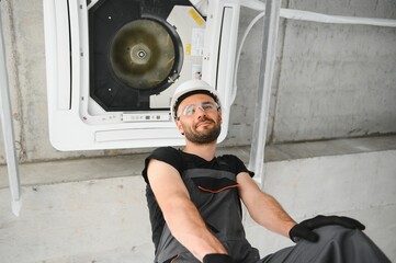 Wall Mural - Happy Male Technician Repairing Air Conditioner