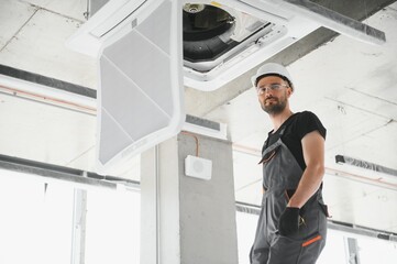 Wall Mural - Happy Male Technician Repairing Air Conditioner