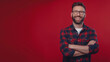 © malik - Young handsome man with beard wearing casual sweater and glasses over red background happy face smiling with crossed arms looking at the camera. Positive person.