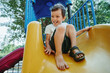 © alexkoral - happy boy rides a slide on the playground in summer