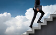 © itakdalee - a man in a suit climbs the stairs against a background of clouds and sunlight, business motivation, success