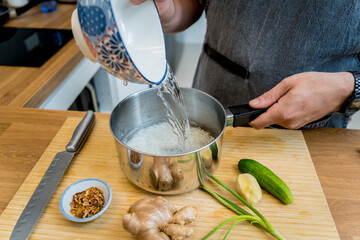 Poster - Chef at the kitchen preparing rice porridge with onion and sesame seeds