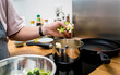 © romaset - Chef at the kitchen preparing lentils soup with cauliflower and broccoli