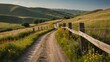 © Kumblack - A wooden fence leading down a country lane with rolling hills in the background