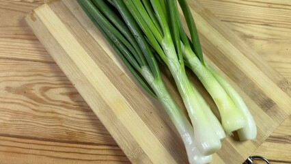 Wall Mural - Peeled young green onion on a cutting board, close-up