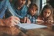 © Natchaya - Parents and children planning their future, with life insurance documents on the table
