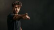 © Adi - A man pointing at something with his finger on a black wall