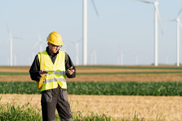 Aufkleber - Engineer with digital tablet works on a field of wind turbines	
