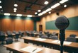 © SR Creative Idea - A microphone in focus against a blurred background of a business seminar room or university classroom podium