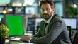 © Adi - Successful Caucasian Businessman Sitting at Desk Working on Green Screen Laptop Computer in Office