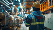 © AdamDiezel - a person in overalls with reflective stripes, a yellow hard hat and a tablet computer against the background of industrial equipment
