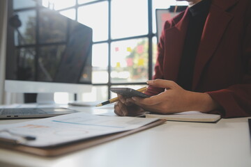 Asian businesswoman in formal suit in office happy and cheerful during using smartphone and working