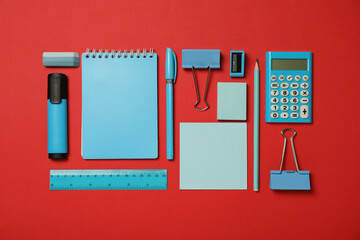 Wall Mural - Flat lay composition with notebook and different stationery on red background