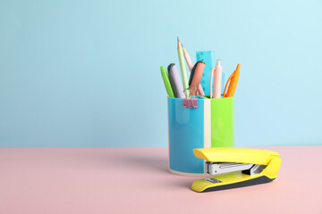 Wall Mural - Stapler and other stationery on color background, space for text