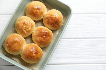 Wall Mural - Delicious dough balls in baking dish on white wooden table, top view. Space for text