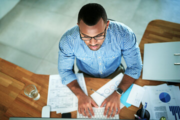 Wall Mural - Top view, businessman and computer at desk in office for research, email and report for company. Male financial advisor, typing and review for documents, statistics and online survey for feedback