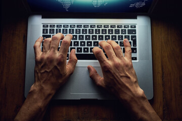 Hands, man and laptop for cyber crime at night, database software and hacking for fraud. Above person, programming malware and spam system or algorithm for phishing, thief and coding script for info