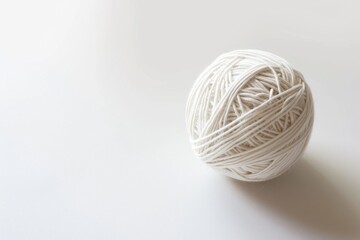 Poster - A ball of yarn sits alone on a clean white surface, ready for knitting or crochet projects