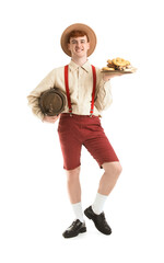 Young man in traditional German clothes with barrel and snacks on white background