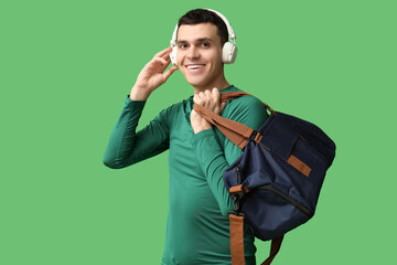 Sticker - Young man with sports bag and headphones on green background