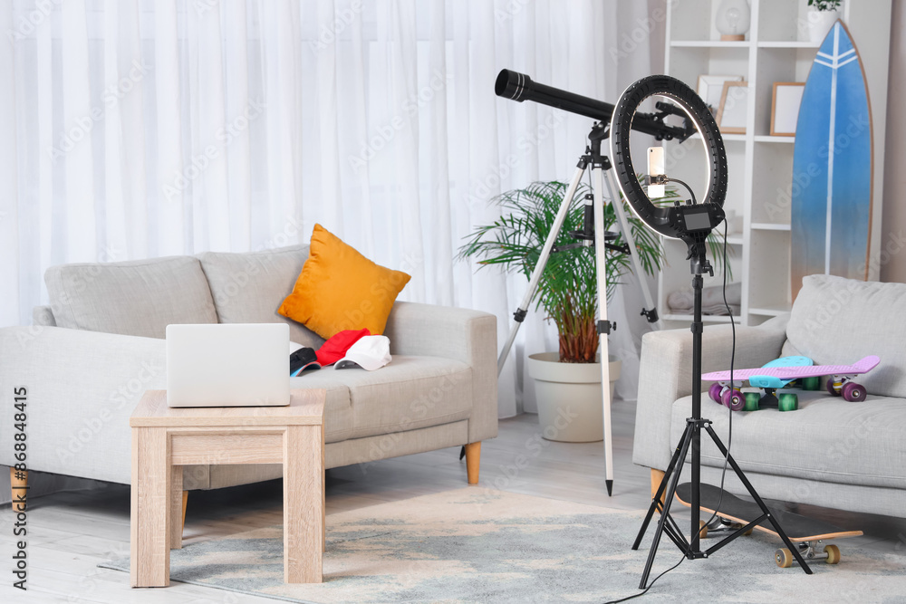 Interior of living room with sofas, ring light and laptop on table
