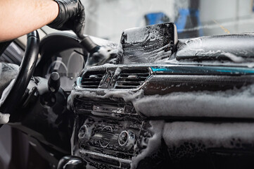 Wall Mural - A mechanic cleans the interior of a car with a brush and foam.