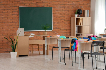 Wall Mural - Interior of classroom with chalkboard, desks and backpacks