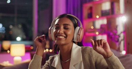 Wall Mural - Music, headphones and Indian girl with sofa dance celebration in house with weekend, relief and good mood. Happy, radio and gen z person streaming audio in neon apartment with night, chill or listen