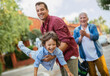 © Geber86 - Father playing with son while grandfather applauds in the background outside
