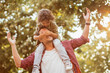 © Geber86 - Joyful father giving piggyback ride to son on suburban street