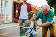 © Geber86 - Father and grandfather teaching young boy to ride a bike on residential street