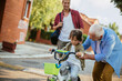 © Geber86 - Father and grandfather teaching young boy to ride a bike on residential street