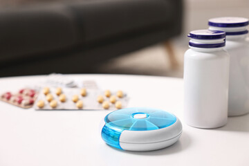 Wall Mural - Different pills, organizer and medical jars at white table, selective focus