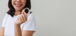 © chinnarach - close up young asian woman smiling with hand holding dental aligner retainer (invisible) at dental clinic for beautiful teeth treatment course concept