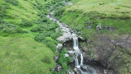 Wall Mural - River with waterfall in Kamchatka, Russia. Green hills and mountains in Tolbachik area. Aerial drone view. Summer landscape
